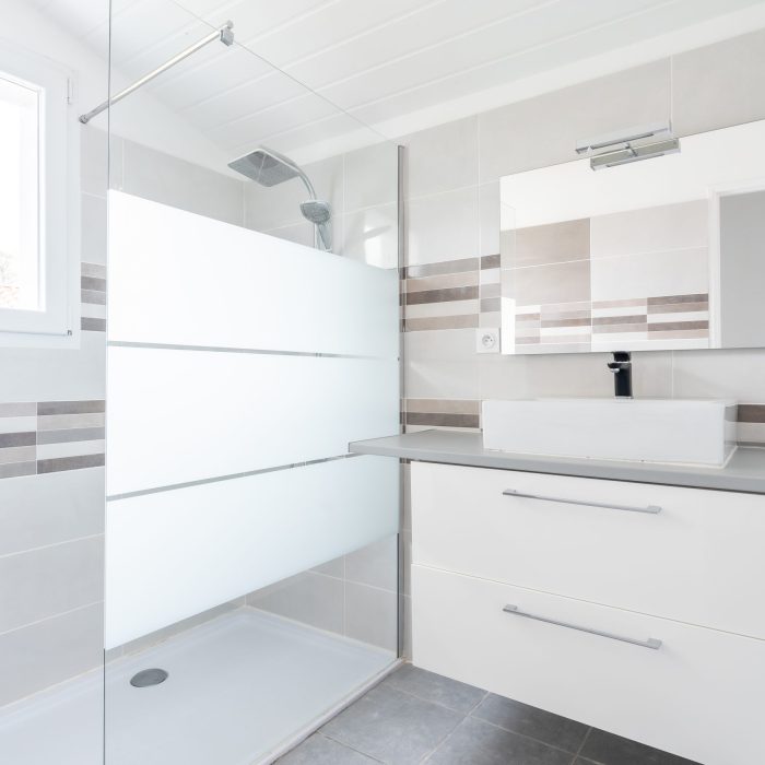 Home bathroom, bright new bathroom interior with tiled glass shower, vanity cabinet, interior designed white and brown